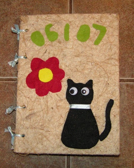 Siva lepenka oblečena v natur kokos papir. Muca, rožice,... narejeno iz filca, mašnice vež