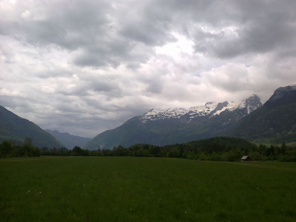 Razgled iz travnika na Kobariški Stol (levo v daljavi) in Kanin (desno)