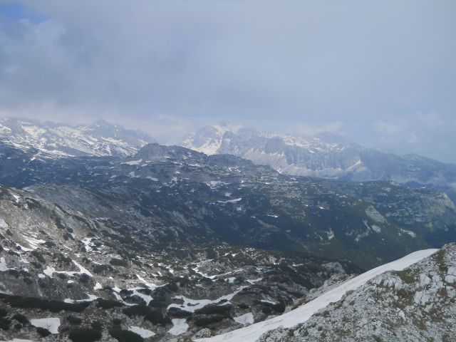Razgled z vrha proti Triglavu, ki se nam za trenutek pokaže izza oblakov