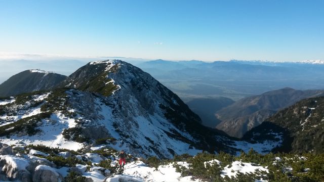 Razgled z vrha v ospredju na Krvavec (levo) in Veliki Zvoh (desno) ter Julijske alpe