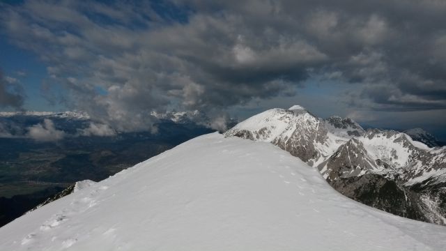 Razgled z vrha na Julijske alpe v oblakih (levo) in Stol (desno)