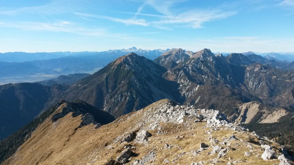 Razgled iz vrha na Julijske alpe (v daljavi) ter Begunjščico, Stol in Vrtačo