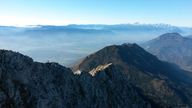 Razgled iz vrha na Tolsti vrh s Kriško goro, Dobrčo in Julijske Alpe (v daljavi)