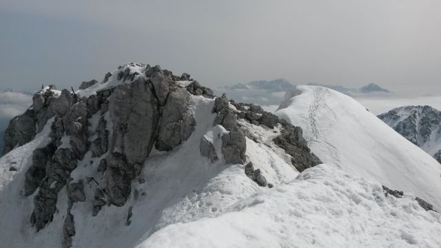Razgled z vrha Vrtače na vzhodni vrh Vrtače ter Kamniško-Savinjske Alpe (v ozadju)