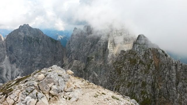 Razgled z vrha Špik Hude police na Koštrunove špice (levo) in Montaževo gorsko skupino