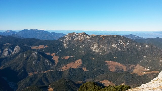 Razgled z vrha Raduhe na Obir (levo), Olševo (desno) in Avstrijske Alpe (v daljavi)