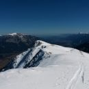 Razgled z vrha Ojstrnika na njegovo vršno pobočje, Dobrač (levo) in Karavanke (desno)