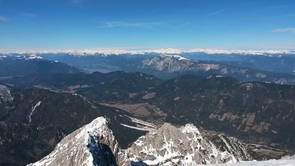 Razgled z vrha Špika na Frdamane police (spredaj) ter Dobrač in Avstrijske Alpe (zadaj)