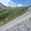 Koča na Kamniškem sedlu in z melišča lepo vidna pot.